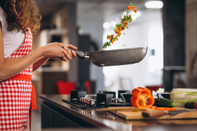 woman-chef-cooking-vegetables-pan.jpg