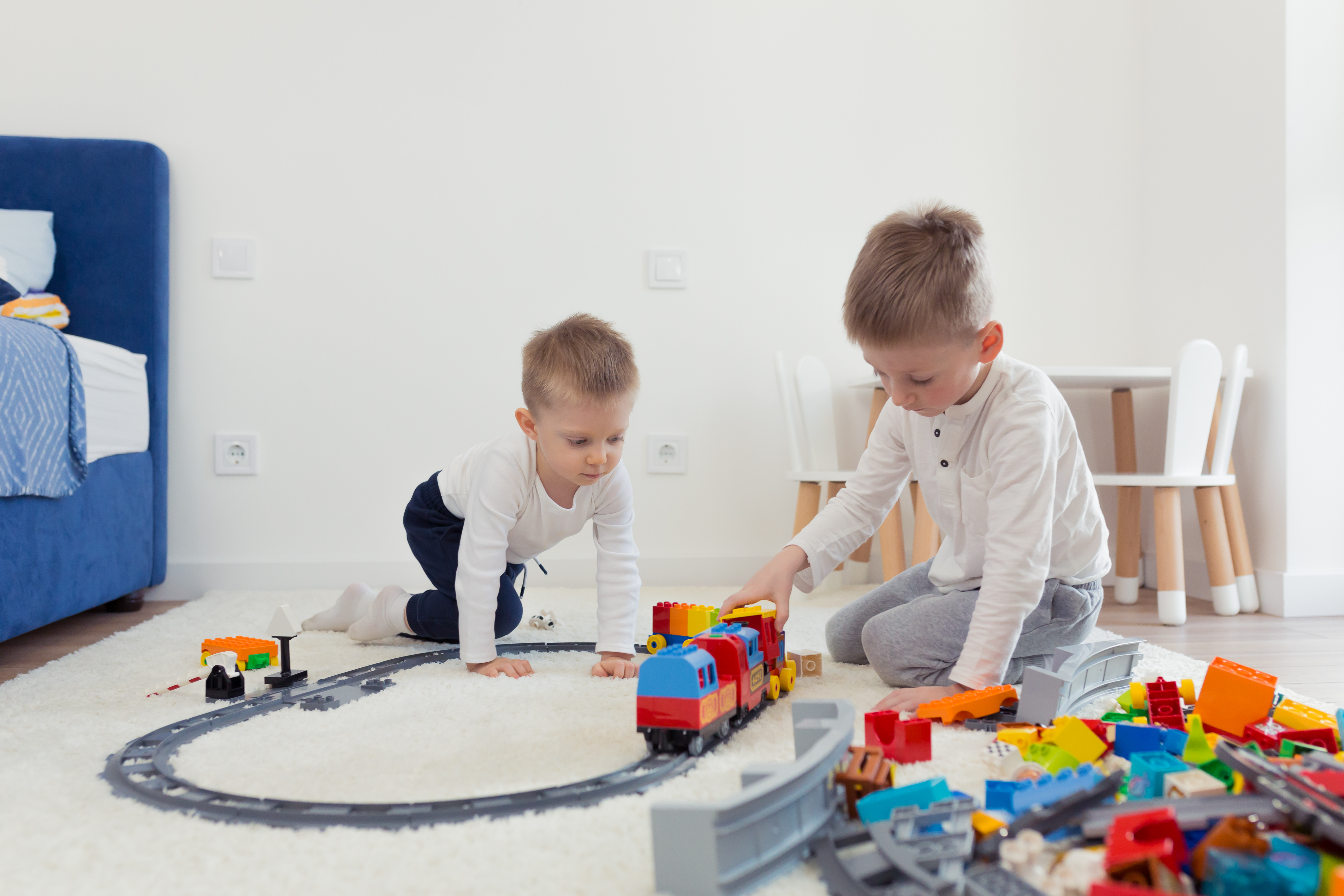 two-little-brothers-have-fun-their-nursery-play-constructor-train.jpg